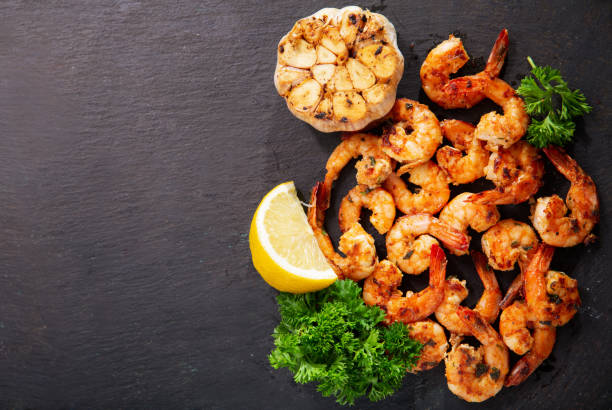 istock grilled shrimps with lemon and parsley, top view 1277210448