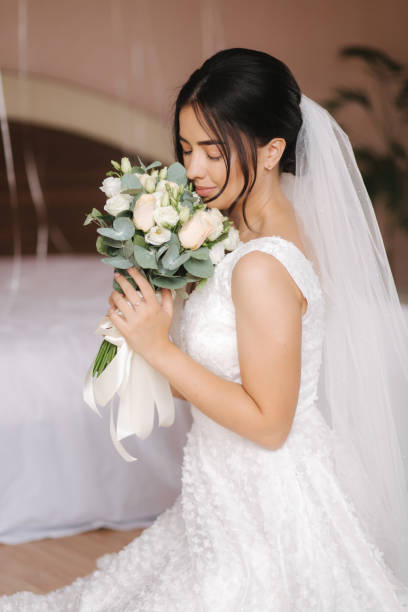 istock Happy bride sit in wedding dress and smiled. Bridde with bouquet 1277210804