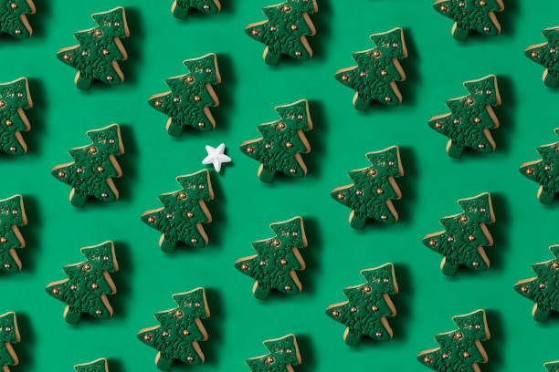 Christmas Tree Cookies in a Row on Green Background Christmas tree shaped cookies in a row on green background christmas cookies pattern stock pictures, royalty-free photos & images