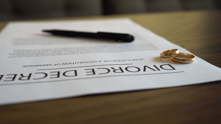 Wife signing decree of divorce agreement prepared by lawyer.