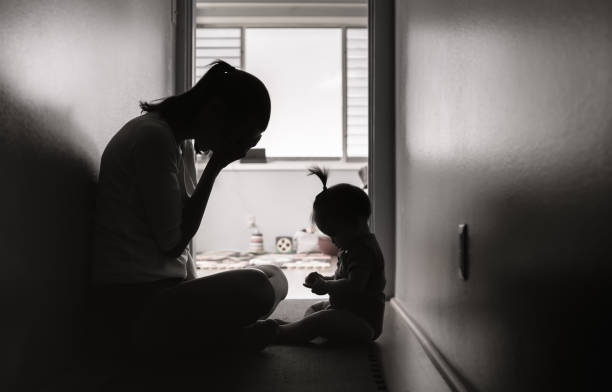 Stressed mother with her baby girl at home. Stressed and tired mother sitting on the floor with her baby girl. 2 5 months photos stock pictures, royalty-free photos & images