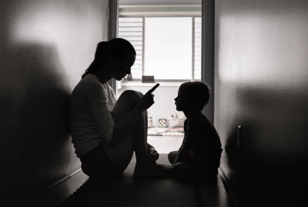 istock Young sad boy watching his mom using a phone. 1277213560