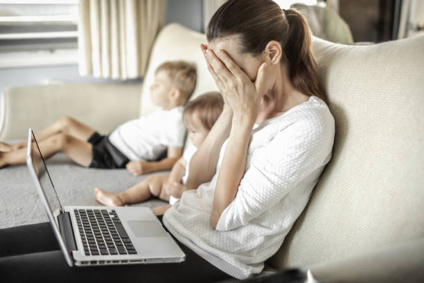 istock Stressed frustrated mother at home with children working on computer. 1277214342
