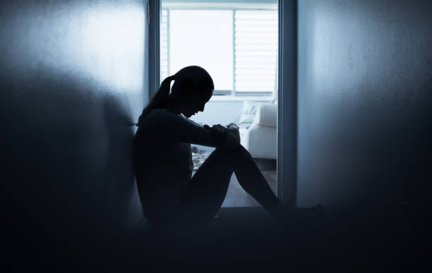 istock Young woman sitting alone on floor at home feeling sad looking down. 1277214444