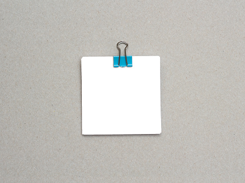 Blank white paper fastened with paper clips on kraft background. Blank note paper.