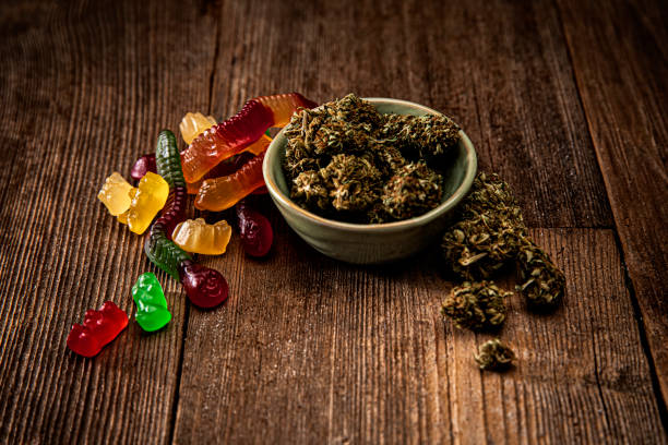 Cannabis bud and oil for Medicinal Use on a retro wood background This is a stock photograph involving cannabis, marijuana and its implications in America has just slowly been legalized and used for medicinal and medical purposes and what that means to our economy and culture. cannabis gummy bears stock pictures, royalty-free photos & images