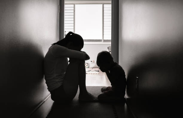 triste madre e figlio seduti sul pavimento a casa. - violenza donne foto e immagini stock