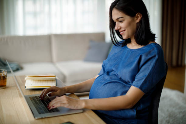 istock Pregnant woman using laptop at home 1277221076