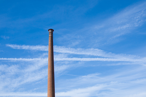 Factory Chimney against deep blue sky, one cloud