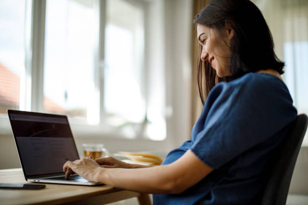 istock Pregnant woman using laptop at home 1277222041