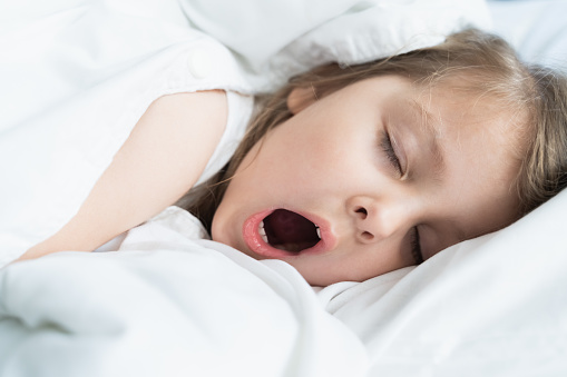 Little snoring girl, sleeping on pillow in bed with closed eyes. Evening late going to bed. Early morning wake up,rise to kindergarten,school.Bedtime,sweet dreams.Kids correct daily routine for child.