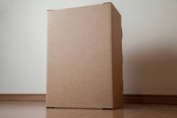 istock Cardboard box with order placed on the floor in an empty room with a neutral background 1277224486