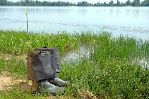 Fishing, rubber boots on the banks of the river. Fishing concept.
