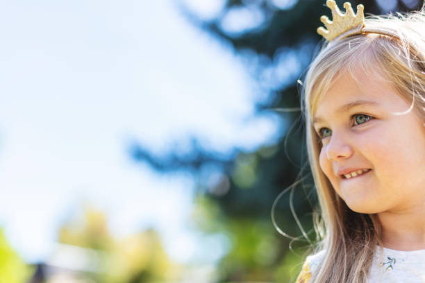 In Western Colorado Young Female Child Standing Outdoors Among Trees on a sunny Fall Day Looking into the Distance; Part of a Series (Shot with Canon 5DS 50.6mp photos professionally retouched - Lightroom / Photoshop - original size 5792 x 8688 downsampled as needed for clarity and select focus used for dramatic effect)