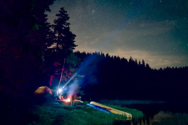 People Are Lighting The Sky With A Forehead Lanterns While They Are Sitting Next To The Campfire At The Campsite