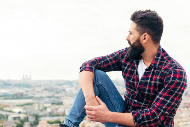 istock man sitting on the rooftop observing the city 1277238547