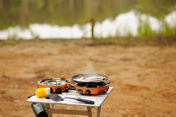 istock Camping stove outdoors near lake with cooking bacon 1277239594