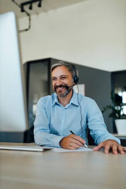 man using computer and smiling. Online video chat with business partners