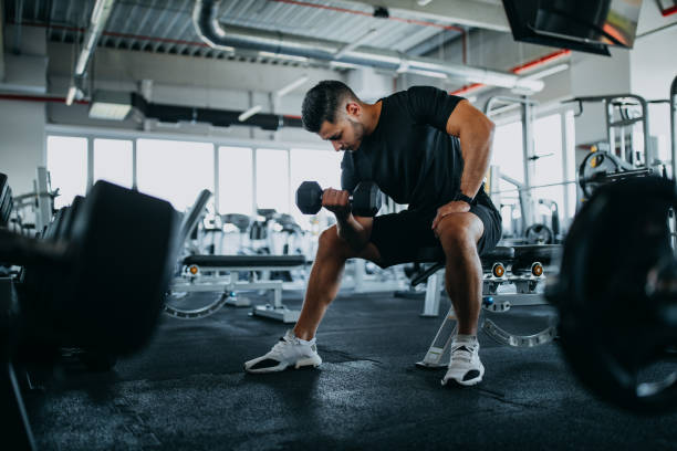 istock At gym, sitting and holding weight. 1277242846
