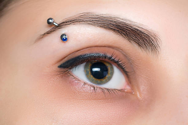 augenbrauenpiercing. wimpern-tattoo. kosmetische verfahren - pierced stock-fotos und bilder