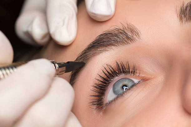 istock Permanent eyebrow makeup. Cosmetologist applying tattooing of eyebrows. Close up shoot. 1277244227