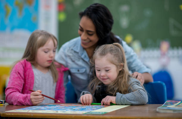 istock Teacher aids students with Down syndrome 1277246243