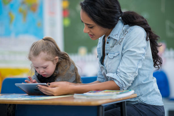 istock Teacher aids students with Down syndrome 1277246252