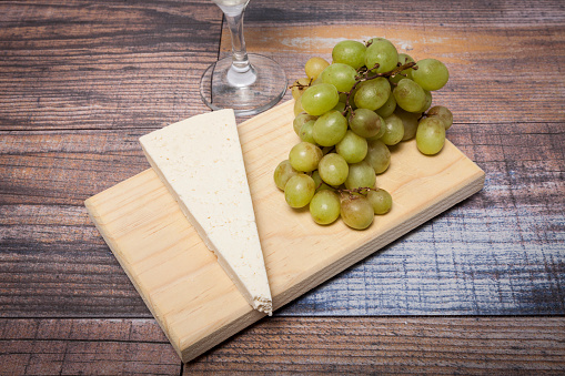 glass of cider on the table with green grapes and cork decoration