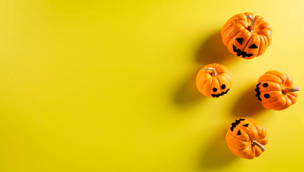 istock Halloween decorations made from ghost pumpkin on pastel yellow background. Flat lay, top view with copy space for text. 1277251042