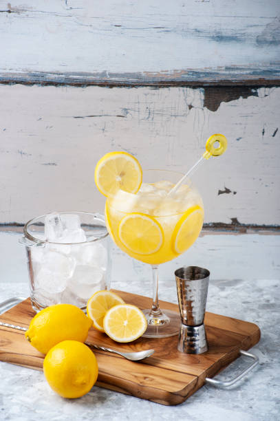 istock Limoncello and gin cocktail on a kitchen board, ice bucket, whole and sliced lemons and gin dispenser. Copy space 1277251655