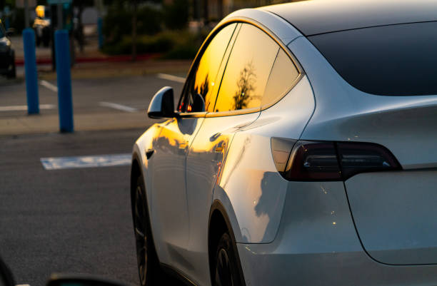 Sunset colors off Tesla Model Y Austin, TX, USA - September 24, 2020: Sunset colors off Tesla Model Y parked in a parking lot outside of Austin in Cedar Park , TX , USA tesla model 3 stock pictures, royalty-free photos & images