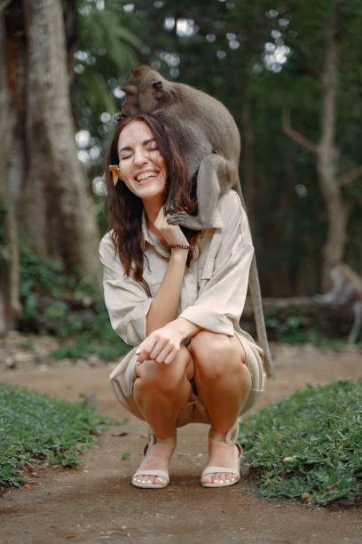 istock Woman on vacation playing with a monkey 1277260786