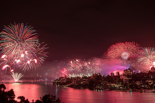 Sydney New Year's Eve fireworks over the harbour with the opera house and harbour bridge in the back.