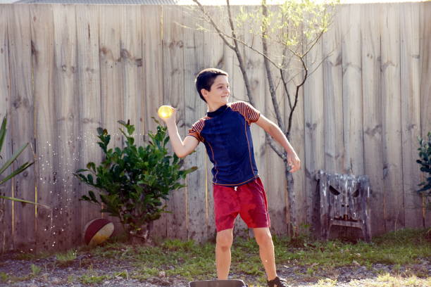 istock Child Throwing Water Bomb in Fight 1277274956