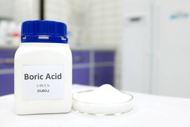 Selective focus of a bottle of pure boric acid chemical compound beside a petri dish with solid crystalline powder substance. White Chemistry laboratory background with copy space. Selective focus of a bottle of pure boric acid chemical compound beside a petri dish with solid crystalline powder substance. White Chemistry laboratory background with copy space. acid stock pictures, royalty-free photos & images