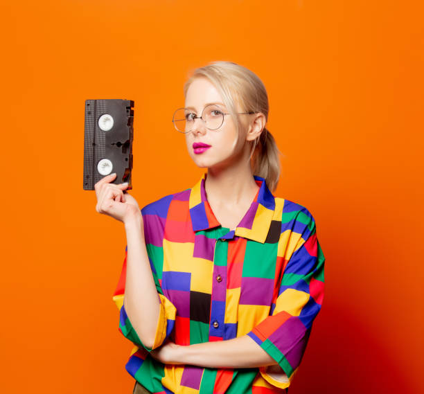 istock Style blonde in 90s shirt and glasses with VHS type 1277278457