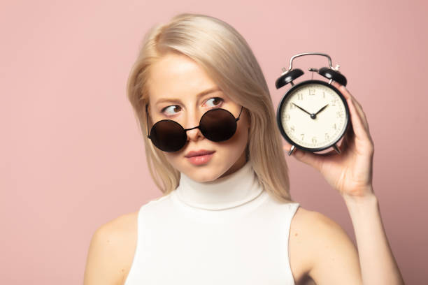 istock Style blonde in top and sunglasses with alarm clock 1277279313