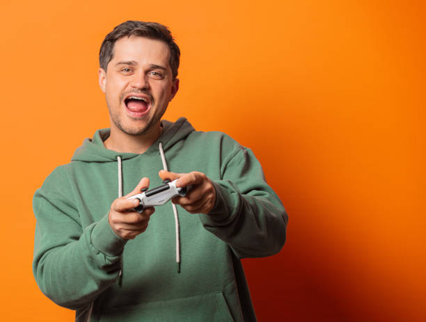 istock guy in face mask and green hoodie game controller 1277279874