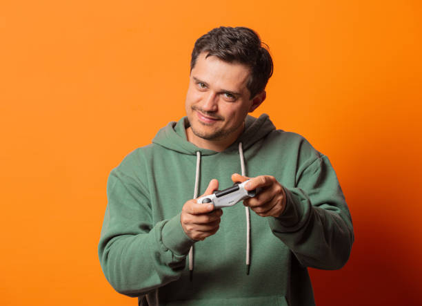 istock guy in face mask and green hoodie game controller 1277279892