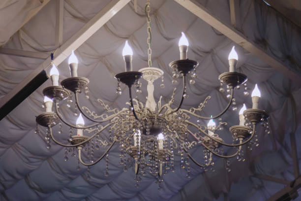 Stylish openwork chandelier made of white material Stylish openwork chandelier made of white material in wedding tent. Close-up of luxury lighting decoration. Copyright space for site antler chandelier stock pictures, royalty-free photos & images