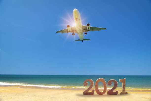 New year 2021 and commercial plane on tropical beach and blue sky background