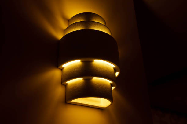 istock Stylish modern lamp on white textured wall 1277282191