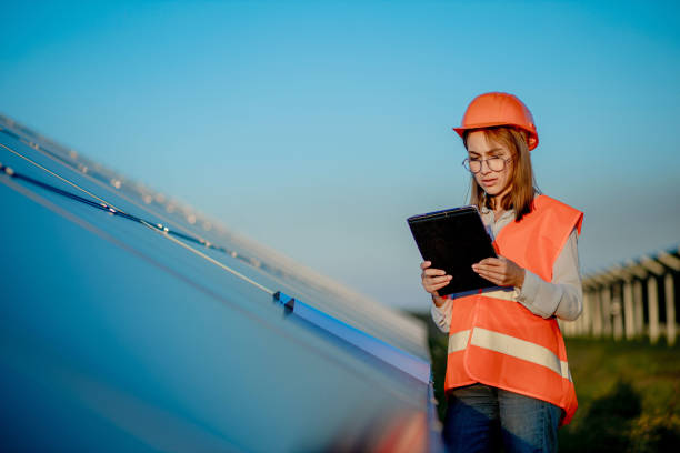 istock Inspector Engineer Woman Holding Digital Tablet Working in Solar Panels Power Farm, Photovoltaic Cell Park, Green Energy Concept 1277285498