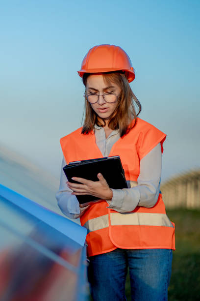 istock Inspector Engineer Woman Holding Digital Tablet Working in Solar Panels Power Farm, Photovoltaic Cell Park, Green Energy Concept 1277285503