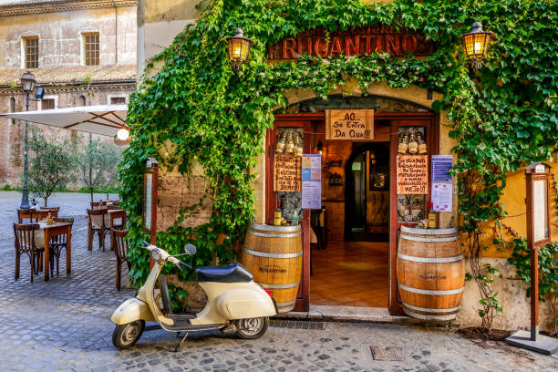 A lovely vintage Vespa outside a typical restaurant in the Trastevere district in the historic heart of Rome Rome, Italy, May 22 -- The entrance of a typical restaurant in the ancient Trastevere district, the most loved and visited roman district by the tourists of the eternal city, with Italian gourmet products and a menu of Roman and Italian cuisine. Photo in High Definition format. italian language stock pictures, royalty-free photos & images