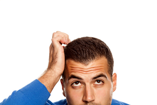 Half portrait of young confused man on white background