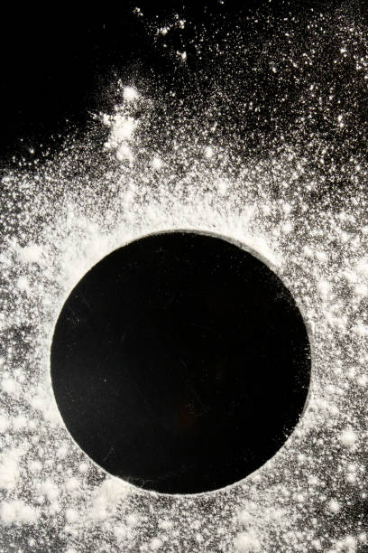 istock Sprinkled wheat flour circle, round spot on black. Top view on blackboard. Baking concept, cooking dough or pastry 1277288986