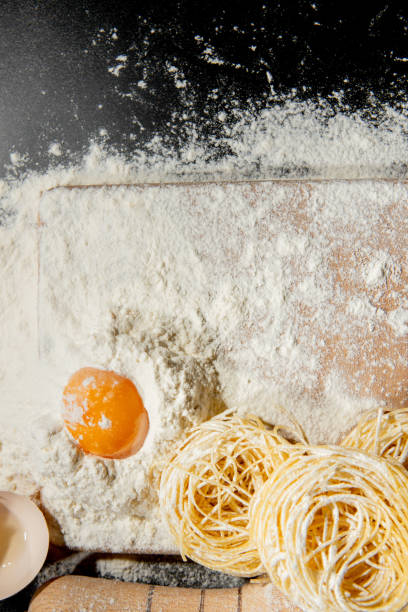 istock Freshly cooked pasta is lying on a dark surface dusted with flour. Italian pasta. Tagliatelle. Raw pasta. Italian pasta recipe. Top view, copy space 1277289030