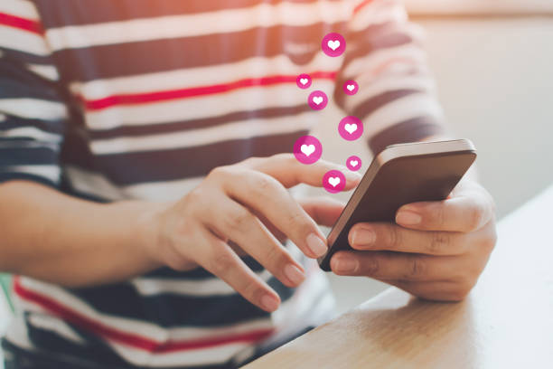 istock Social network sharing and commenting in the online community, Man hand holding smartphone and using application social media with icon heart 1277290430