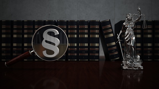Loupe with paragraphs, law books and lady justice statue on the table. 3d illustration.